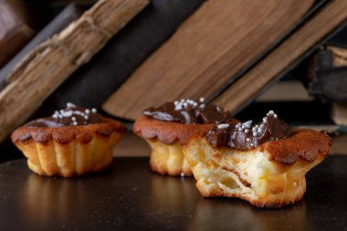 Lezzetli kek Çikolata ve kitap kaybı ile dekore edilmiştir. Tatlı mutfak ahşap bir masa üzerinde. Açık renkli.