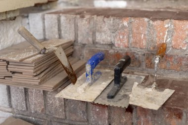 Bodrum katında merdivenlerde fayans döşeme. Hazır çini ve araçları yardımcı programı odasında. Açık renkli.