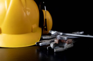 Atölye anahtarı ve kask siyah bir tablo. Atölye işçiler için aksesuarlar. Koyu arka plan.