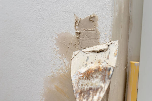 Applying putty to the wall in a new apartment. Renovation and painting of walls at home. Place - home farm.