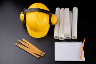 Araçlar ve notlar için bir marangoz atölyesi masada. Bir üretim işçisi için aksesuarlar. Koyu arka plan.