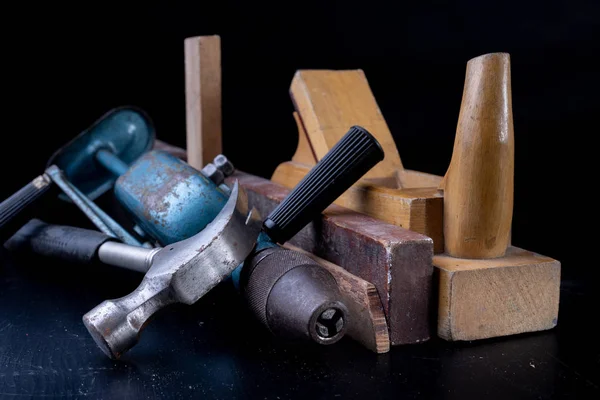 Tools for a carpenter on a workshop table. Accessories for a production worker. Dark background.