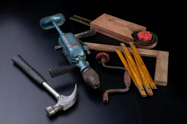 Tools for a carpenter on a workshop table. Accessories for a production worker. Dark background.