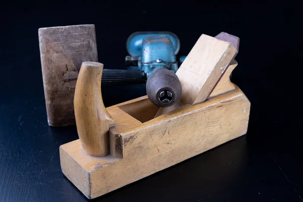 Tools for a carpenter on a workshop table. Accessories for a production worker. Dark background.