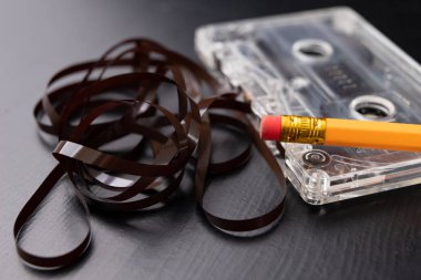 Ses kaseti ve kalem siyah bir tablo. Eski manyetik veri taşıyıcı. Koyu arka plan.