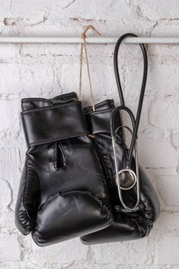 Siyah boks eldivenleri ve tıbbi bir stetoskop bir tuğla duvar. Eğitim aksesuarları. Beyaz arka plan.