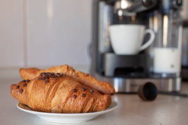 Taze yapılmış kahve kahve makinesi ve lezzetli tatlı çörek. Ev mutfakta kahvaltı. Açık renkli.