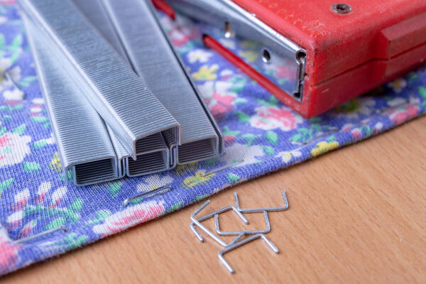 Tacker and Staples used to upholster furniture. Accessories for employees in the carpentry shop. Light background