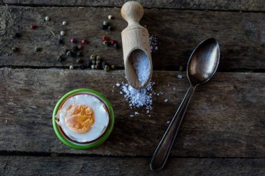 Haşlanmış yumurta ve tuz ahşap bir karanlık tablo.