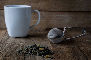 Sıcak çay ve bir kupa bir ahşap mutfak masasında