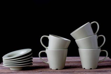 Kahve bardağı ahşap bir masa üzerinde. Siyah arka plan.