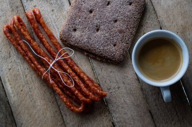 Ahşap bir masa ekmek ve kahve kupa. Yemek kahvaltı hazırladım. Koyu arka plan.
