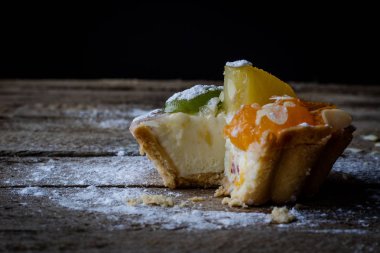 Tatma cupcake ahşap mutfak masasında taze meyve ile. Koyu arka plan.