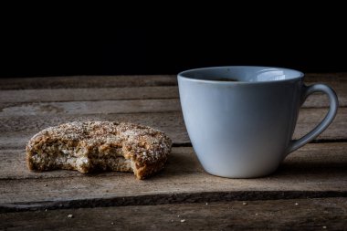 Ahşap bir masa ekmek ve kahve kupa. Yemek kahvaltı hazırladım. Koyu arka plan.