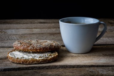 Ahşap bir masa ekmek ve kahve kupa. Yemek kahvaltı hazırladım. Koyu arka plan.