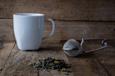 Sıcak çay ve bir kupa bir ahşap mutfak masasında