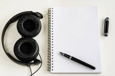 Defter ve kalem ofiste beyaz bir tabloda.