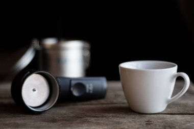 Kahve, süt ve şeker bir ahşap mutfak masasında. Koyu arka plan.