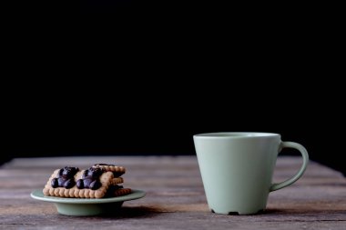 Kupa ve ahşap bir masa üzerinde kahve. Siyah arka plan.