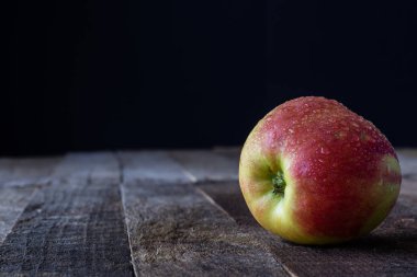 Elma ve rende ahşap mutfak masasında. Koyu arka plan.
