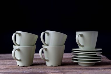 Kahve bardağı ahşap bir masa üzerinde. Siyah arka plan.