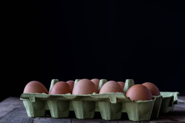 Kağıt ambalaj ahşap mutfak masasında tavuk yumurta.
