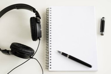 Defter ve kalem ofiste beyaz bir tabloda.