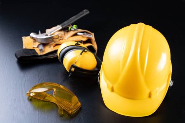 Kask ve aksesuarlar, inşaat işçileri. İçin gerekli aksesuarları inşaat site üzerinde çalışmak. Koyu arka plan.