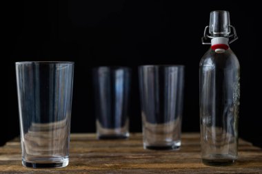 Ahşap bir masa üzerinde cam yemekleri. Siyah arka plan.