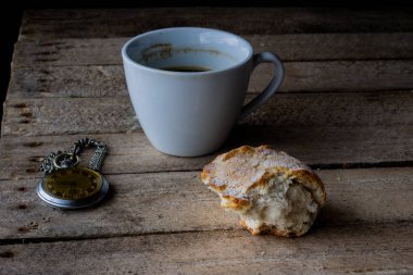 Ahşap bir masa ekmek ve kahve kupa. Yemek kahvaltı hazırladım. Koyu arka plan.