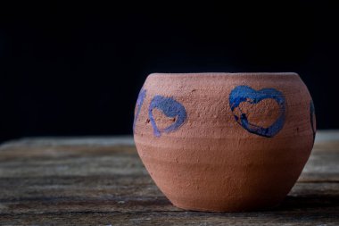 Tahta masadaki kil sürahi. 