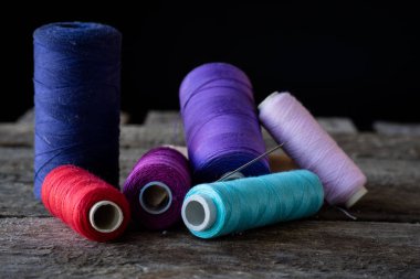 Dikiş ve ahşap bir masaya örgü için araçları. Sıcak kahve bir kupa. Koyu arka plan.