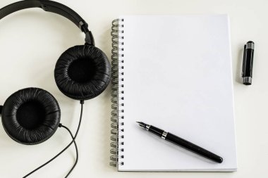 Defter ve kalem ofiste beyaz bir tabloda.