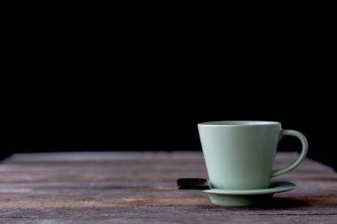 Kupa ve ahşap bir masa üzerinde kahve. Siyah arka plan.