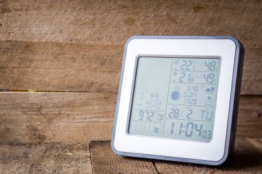 Elektronik hava istasyonu ahşap bir masa üzerinde. Koyu arka plan.