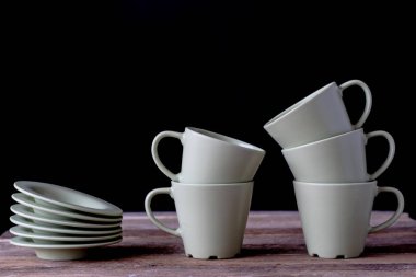 Kahve bardağı ahşap bir masa üzerinde. Siyah arka plan.