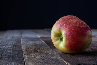 Elma ve rende ahşap mutfak masasında. Koyu arka plan.