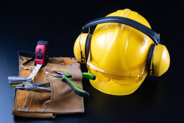 Kask ve aksesuarlar, inşaat işçileri. İçin gerekli aksesuarları inşaat site üzerinde çalışmak. Koyu arka plan.