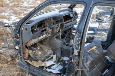 Bir çayır harap bir araba enkazı. Demonte araba iskeleti. Kış sezon.