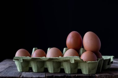 Kağıt ambalaj ahşap mutfak masasında tavuk yumurta.