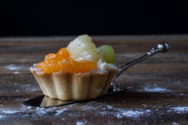 Lezzetli kek mutfak masasının üzerinde. Koyu arka plan.