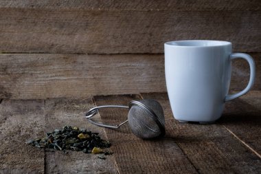 Sıcak çay ve bir kupa bir ahşap mutfak masasında