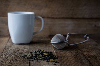 Sıcak çay ve bir kupa bir ahşap mutfak masasında