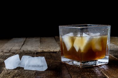 Soğuk içecekler ahşap bir masa üzerinde hazırlanıyor. Koyu arka plan.