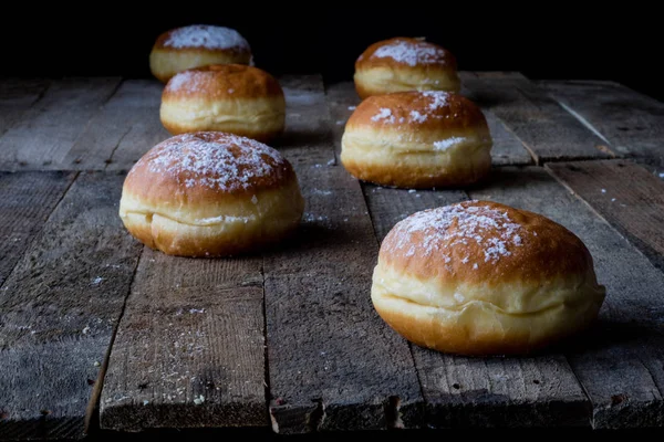 Pyszne Pączki Drewnianym Stole Pyszny Deser Przygotowany Kuchni Ciemne Tło — Zdjęcie stockowe