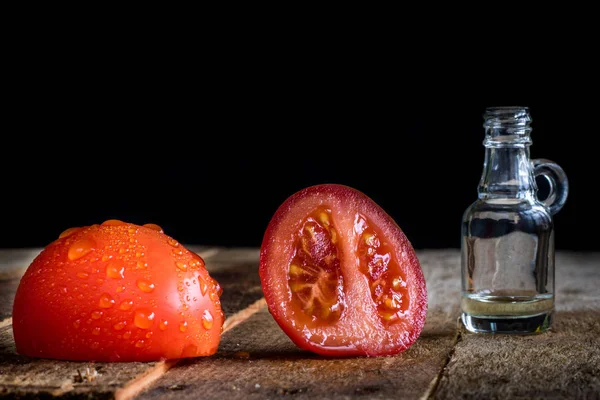 Italian tasty food, olive oil, white cheese and tomatoes. Black background.