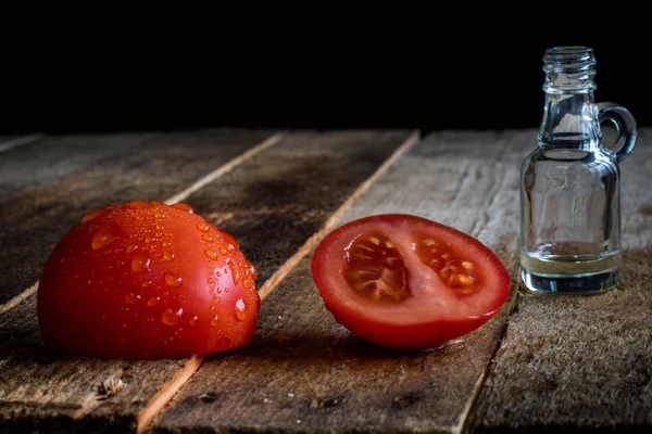 Italian tasty food, olive oil, white cheese and tomatoes. Black background.