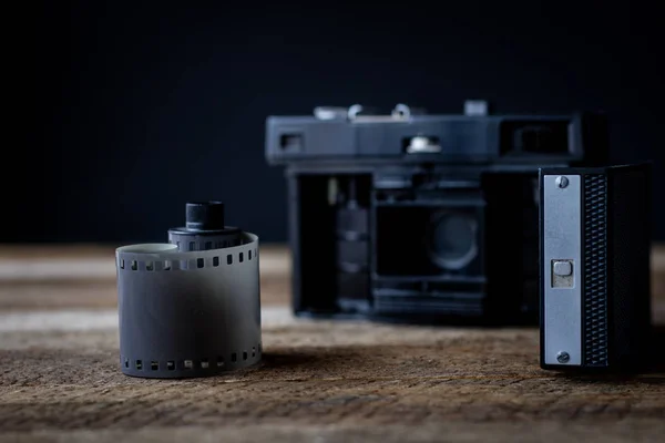 Old analog camera on a wooden table and accessories.