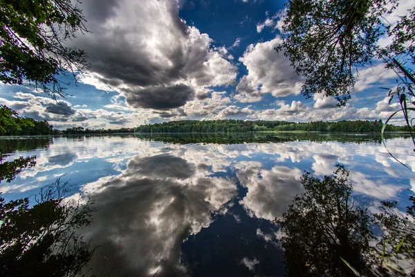 Cloudy sky reflected in the lake\'s mirror.