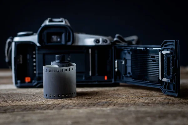 Old analog camera on a wooden table and accessories.